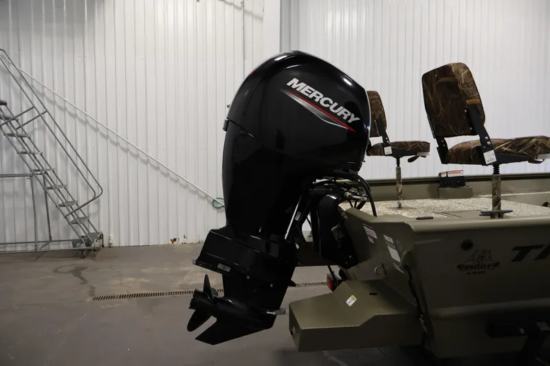 Slide: The Image of 2022 Tracker Grizzly 2072 MVX CC with Mercury outboard motor in a garage setting. - 37