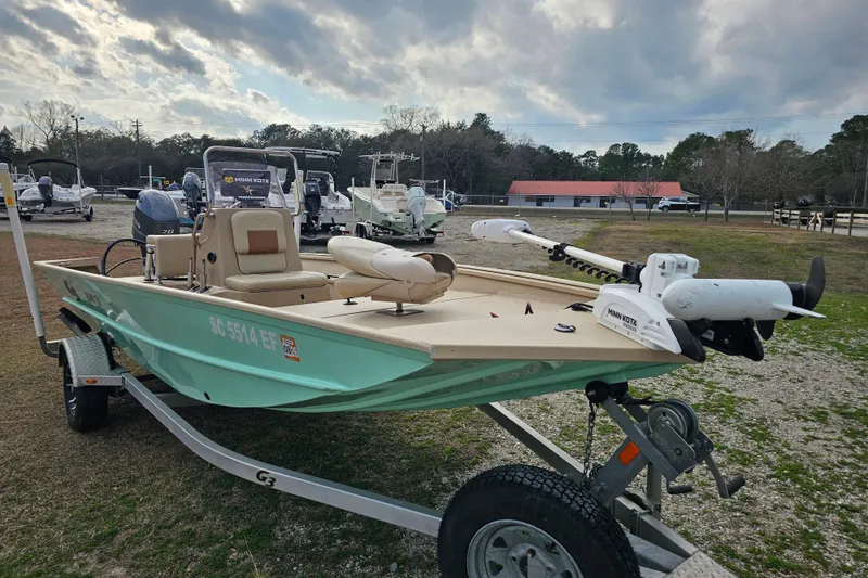 Slide: The Image of 2022 G3 Bay 17 boat on trailer, featuring Minn Kota motor, parked outdoors. - 5