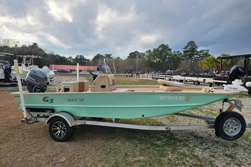 Slide: The Image of 2022 G3 Bay 17 boat on trailer, parked outdoors under cloudy sky. - 6