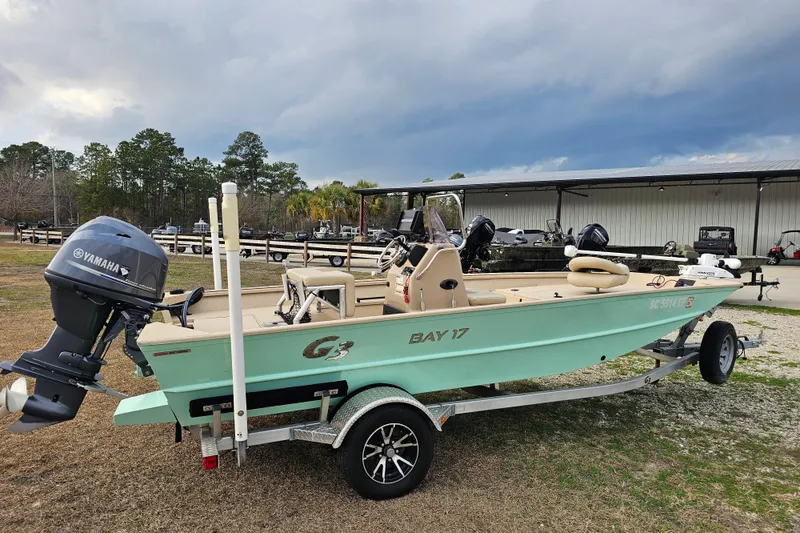 Slide: The Image of 2022 G3 Bay 17 boat with Yamaha motor on trailer, parked outdoors. - 7