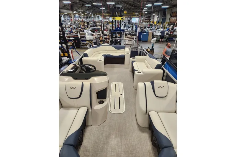 Slide: The Image of 2026 Avalon LSZ Elite 21' pontoon boat interior with luxurious seating in a factory setting. - 5