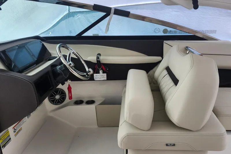 Slide: The Image of Interior of 2026 Regal LX4 boat with steering wheel and beige seating. - 18