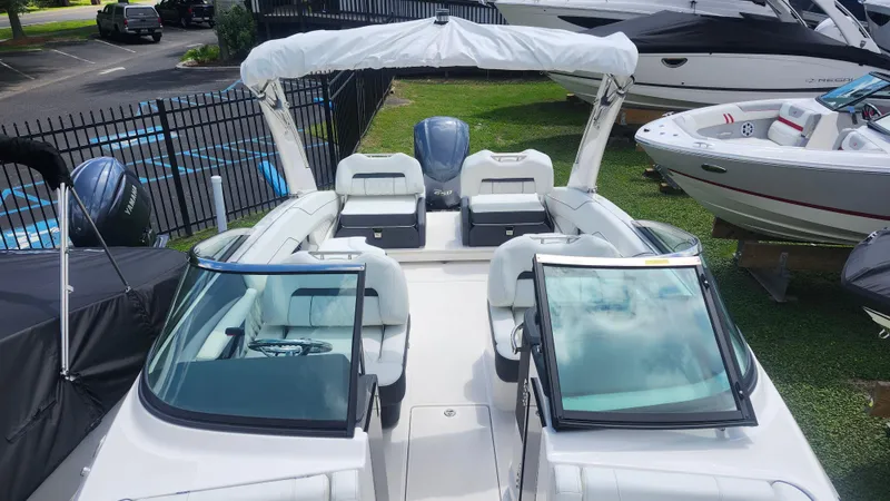 Slide: The Image of 2026 Regal LX4 boat with sleek interior, parked outdoors near other boats. - 4