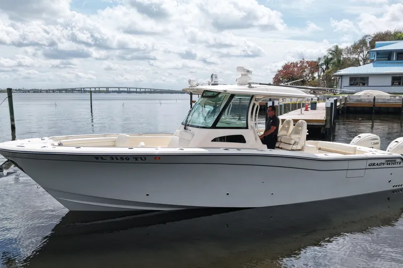 The Image of 2024 Grady-White Canyon 336 boat docked on a calm waterfront. - 0