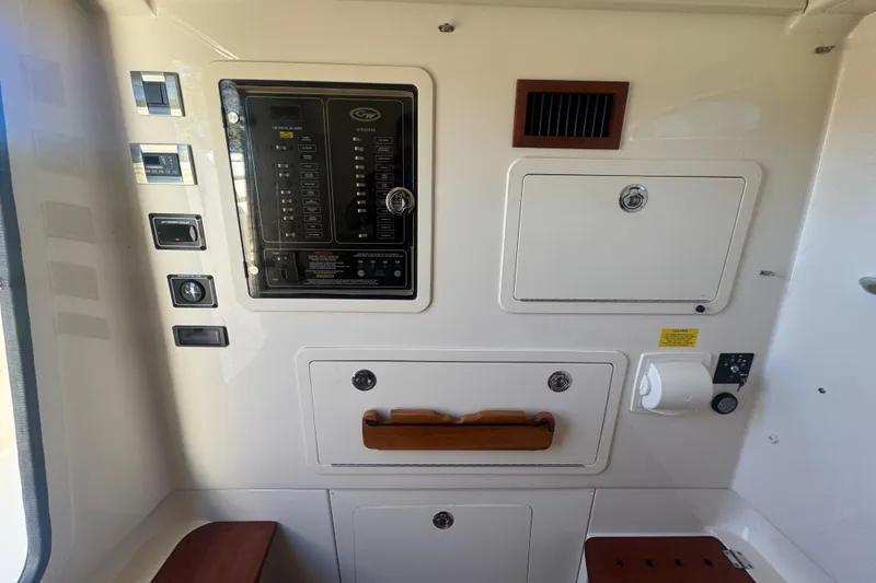 Slide: The Image of 2024 Grady-White Canyon 336 control panel with switches and storage compartments. - 36