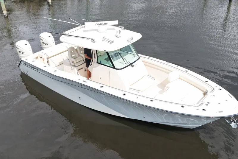 Slide: The Image of 2024 Grady-White Canyon 336 boat on water, featuring sleek design and triple outboard engines. - 5