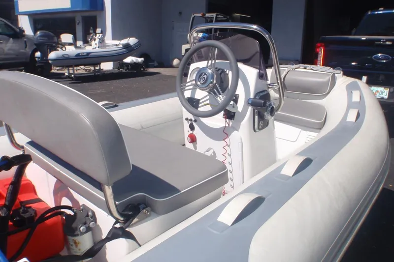 Slide: The Image of 2021 Gala A300L inflatable boat with steering console and seating, parked outdoors. - 3
