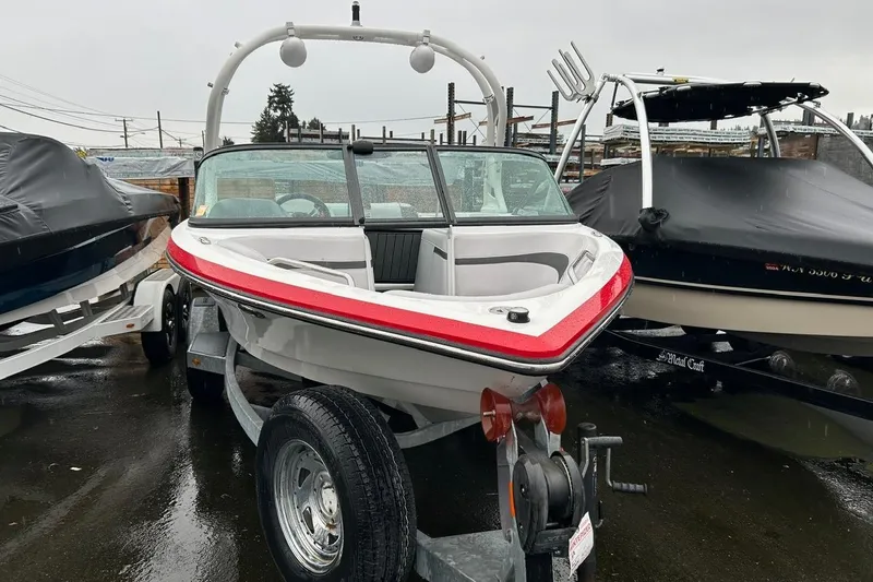 Slide: The Image of 2017 Nautique Ski Nautique 200 Open Bow boat on trailer, parked outdoors. - 2