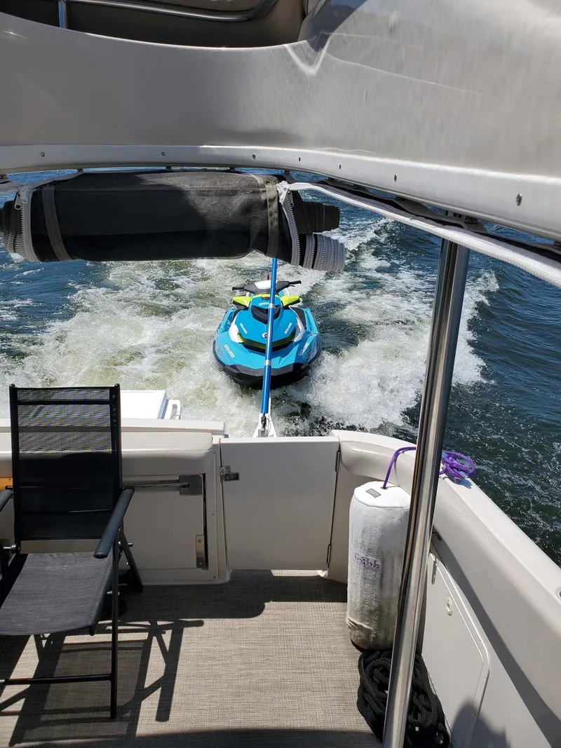 Slide: The Image of Regal 3780 yacht from 2001 towing a blue jet ski on the water. - 7