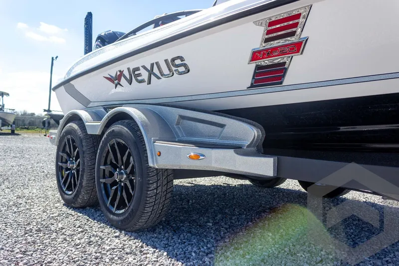 Slide: The Image of 2026 Vexus VXs20 boat trailer with dual black wheels on gravel surface. - 18