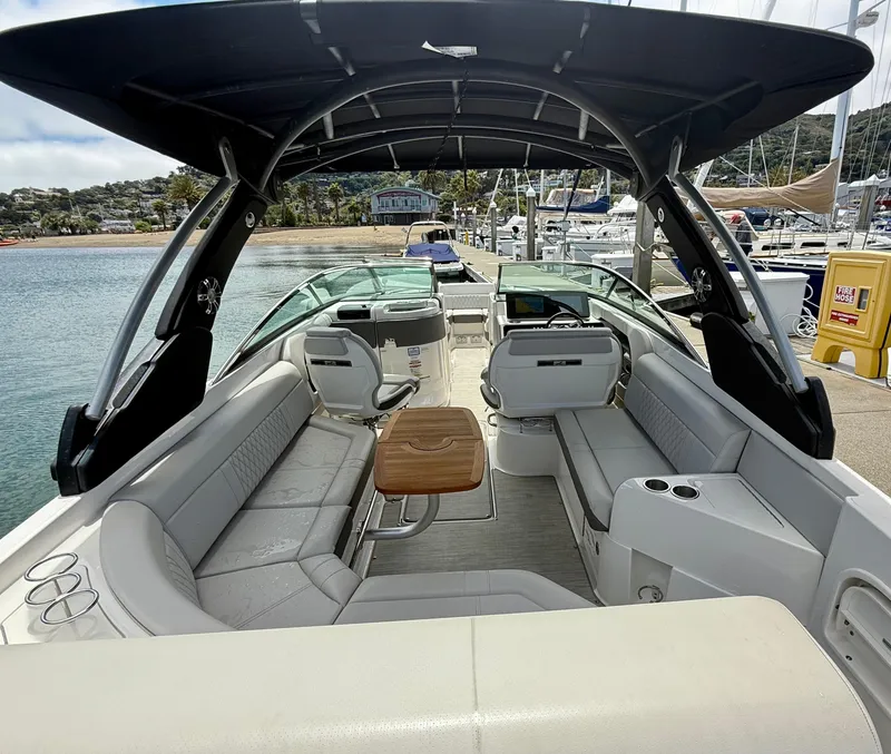 Slide: The Image of 2020 Sea Ray SLX 280 boat interior with seating and table, docked at marina. - 13