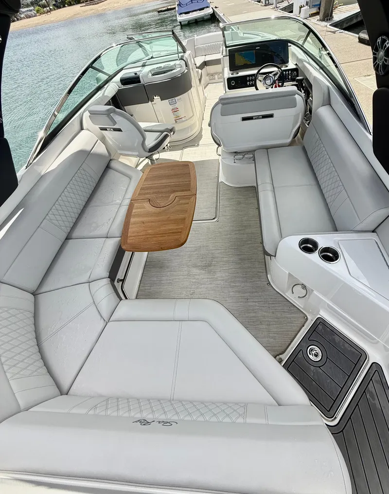 Slide: The Image of 2020 Sea Ray SLX 280 boat interior with luxurious seating and wooden table. - 14