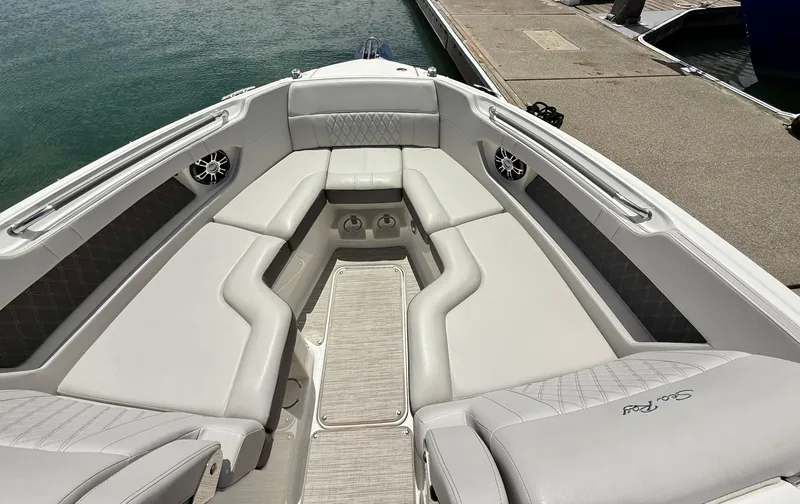 Slide: The Image of 2020 Sea Ray SLX 280 boat interior with luxurious seating and speakers, docked by the water. - 17