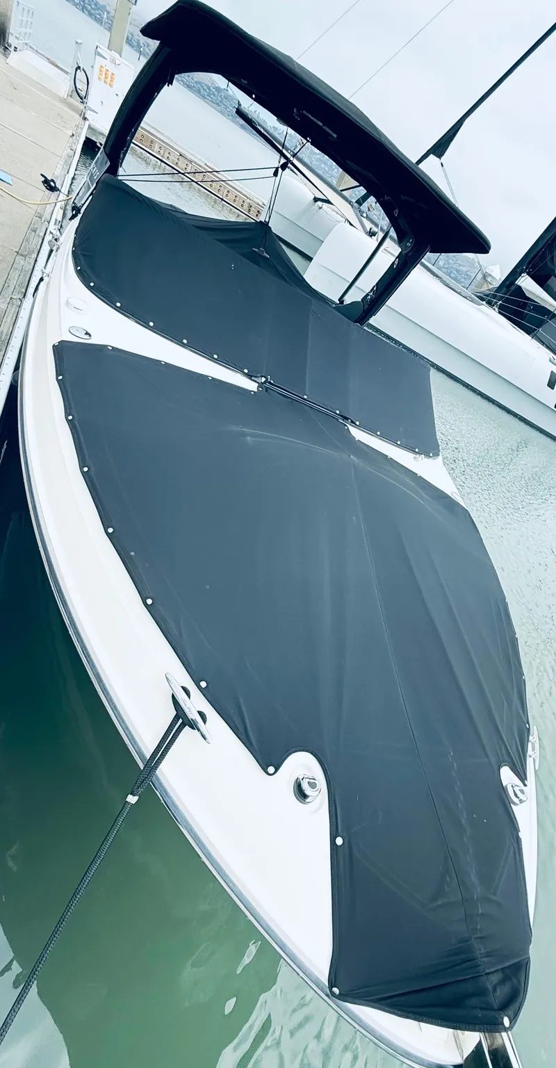 Slide: The Image of 2020 Sea Ray SLX 280 boat with black cover docked at marina. - 25