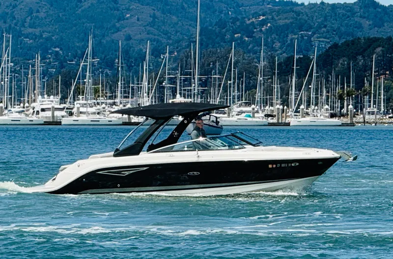Slide: The Image of 2020 Sea Ray SLX 280 boat cruising in a marina with mountains in the background. - 5