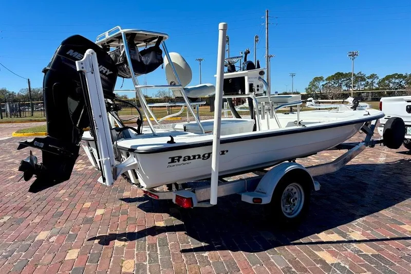 Slide: The Image of 2009 Ranger Banshee boat on trailer with Mercury outboard motor, parked on brick pavement. - 2