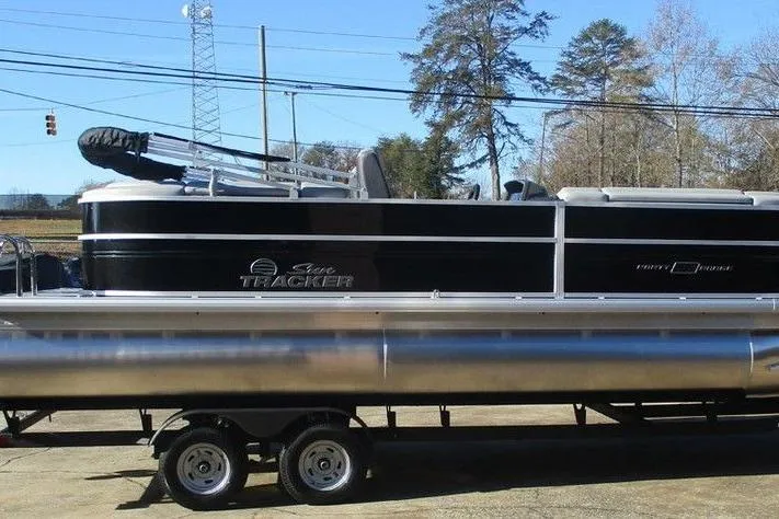 Slide: The Image of 2026 Sun Tracker Party Barge 22 DLX pontoon boat on trailer, parked outdoors. - 4