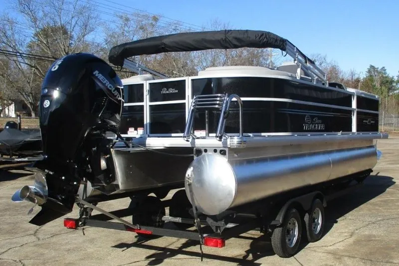 Slide: The Image of 2026 Sun Tracker Party Barge 22 DLX pontoon boat on trailer, featuring Mercury outboard motor. - 5