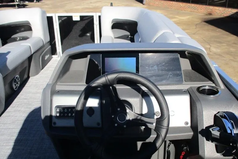 Slide: The Image of 2026 Sun Tracker Party Barge 22 DLX dashboard with steering wheel and control panel. - 9
