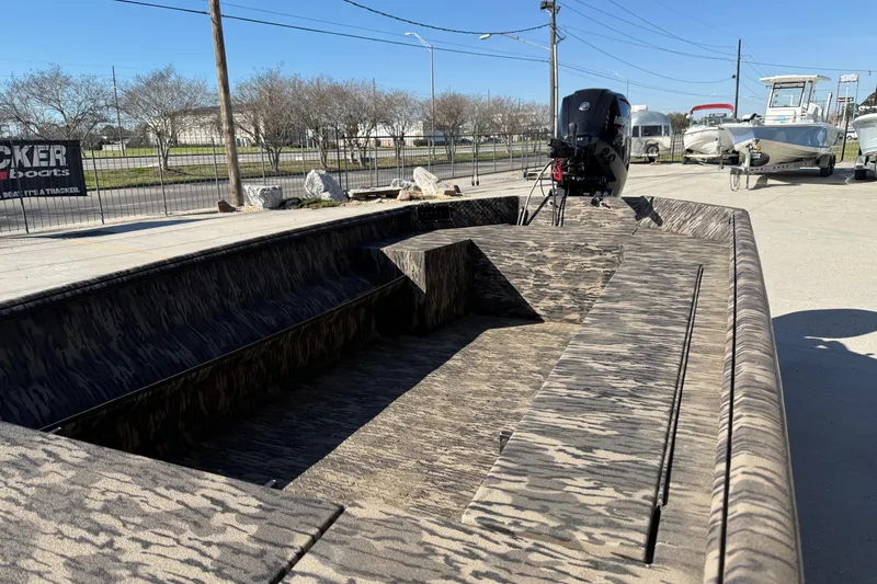 Slide: The Image of 2024 Havoc River Rat 1756 boat with camouflage design, parked outdoors. - 5