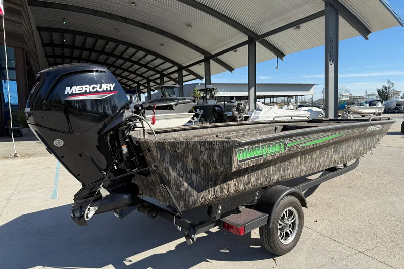 Slide: The Image of 2024 Havoc River Rat 1756 boat with Mercury engine, parked under a metal canopy. - 7