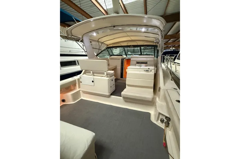 Slide: The Image of 1998 Tiara Yachts 3500 Open interior with seating and helm, under covered storage. - 14