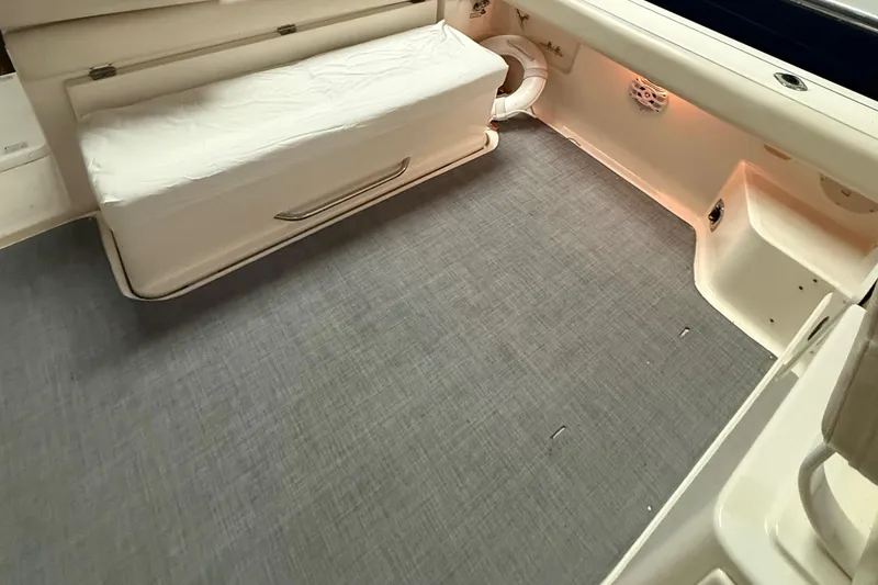 Slide: The Image of 1998 Tiara Yachts 3500 Open boat interior with cushioned seating and carpeted flooring. - 17