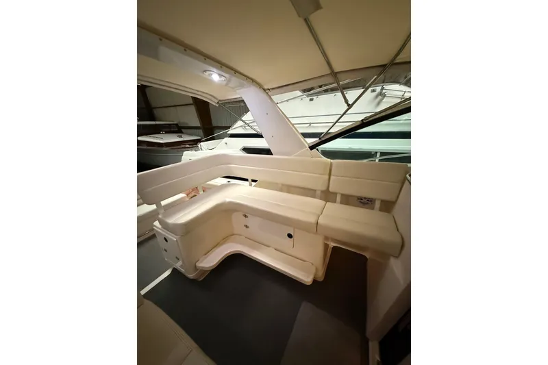 Slide: The Image of Interior seating of 1998 Tiara Yachts 3500 Open, featuring cream-colored upholstery. - 19