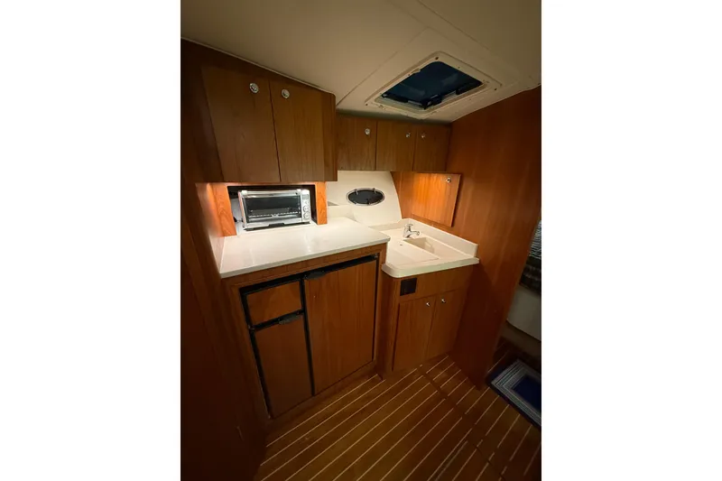 Slide: The Image of 1998 Tiara Yachts 3500 Open galley with wood cabinetry and compact appliances. - 33