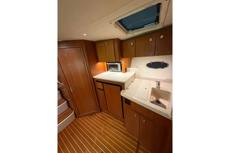 Slide: The Image of 1998 Tiara Yachts 3500 Open interior with wood cabinetry and compact kitchen area. - 34