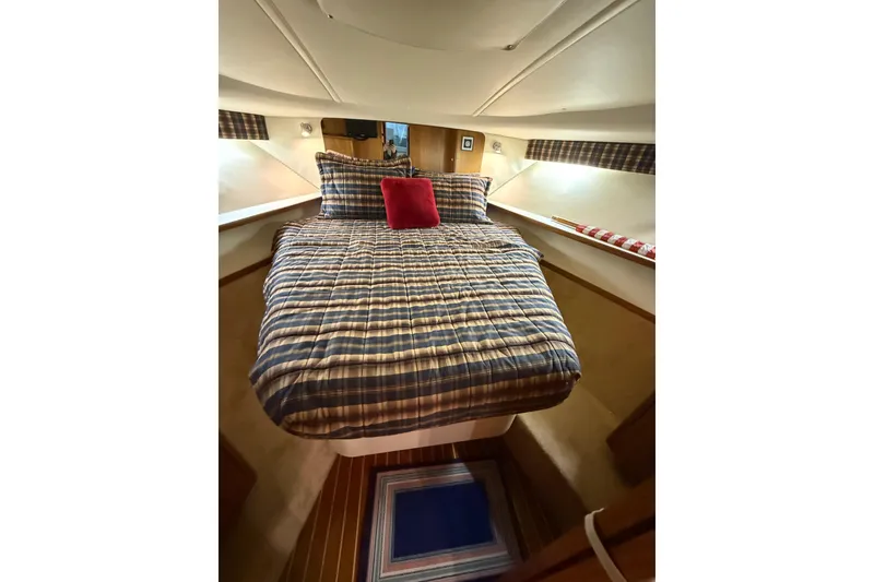 Slide: The Image of Cozy cabin interior of 1998 Tiara Yachts 3500 Open with plaid bedding and red accent pillow. - 37