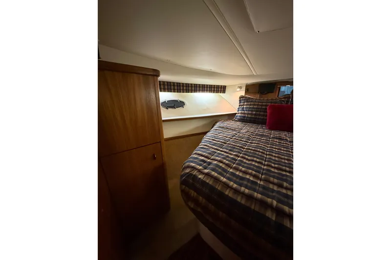 Slide: The Image of Cozy cabin interior of 1998 Tiara Yachts 3500 Open with plaid bedding and wooden cabinetry. - 38