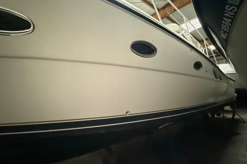 Slide: The Image of 1998 Tiara Yachts 3500 Open in storage, showcasing sleek hull design. - 50