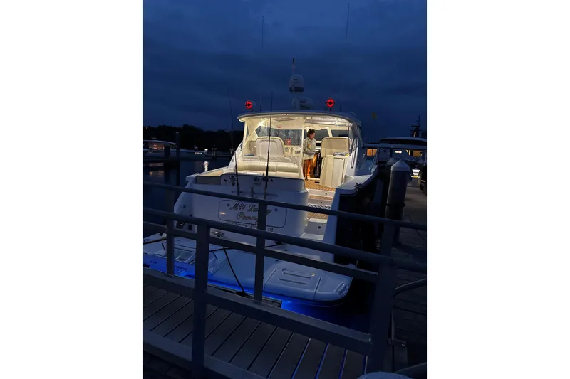 Slide: The Image of 2006 Tiara Yachts 4300 Sovran docked at night with illuminated interior. - 10