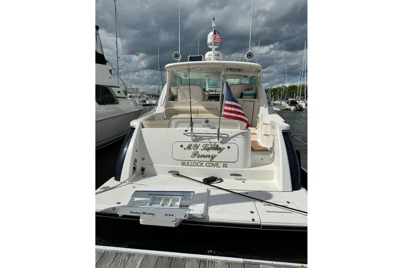 Slide: The Image of 2006 Tiara Yachts 4300 Sovran docked, displaying American flag, overcast sky. - 12