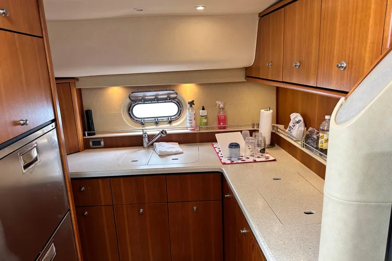 Slide: The Image of 2006 Tiara Yachts 4300 Sovran galley with wood cabinetry and modern amenities. - 17