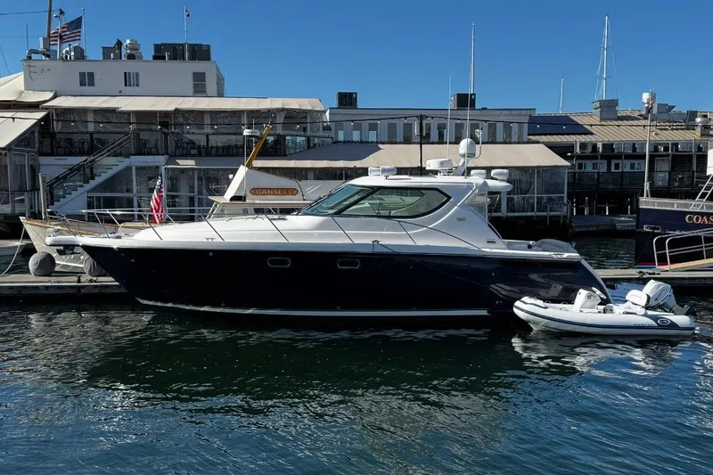 Slide: The Image of 2006 Tiara Yachts 4300 Sovran docked at a marina with a small boat. - 2