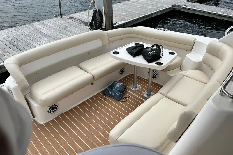 Slide: The Image of 2006 Tiara Yachts 4300 Sovran cockpit with beige seating and table, docked by the water. - 24