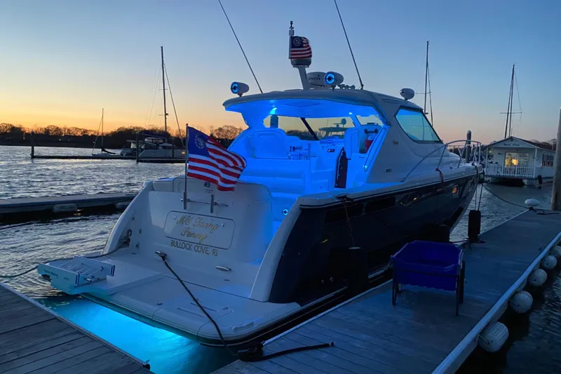 Slide: The Image of 2006 Tiara Yachts 4300 Sovran docked at sunset with blue interior lighting. - 4