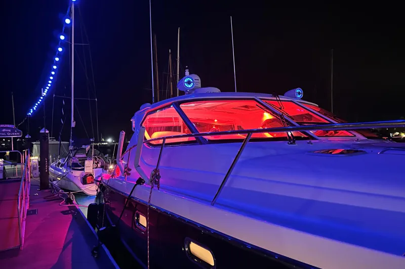 Slide: The Image of 2006 Tiara Yachts 4300 Sovran docked at night with vibrant lighting. - 5