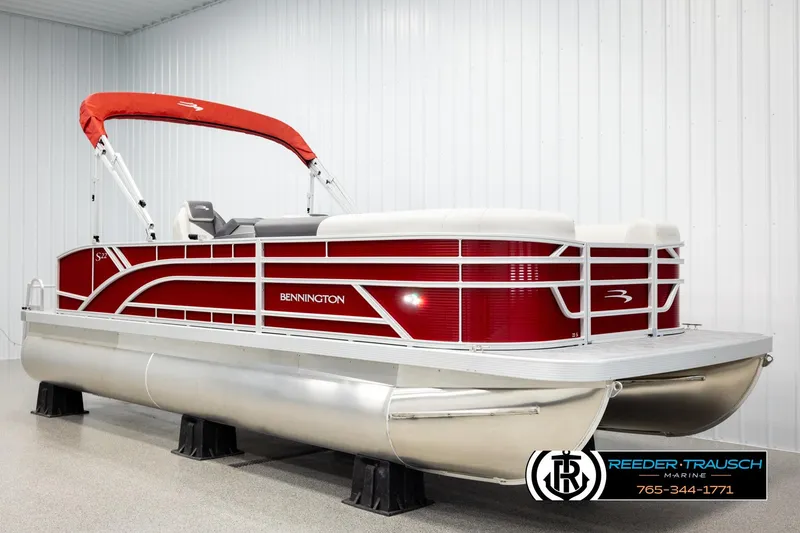 Slide: The Image of 2026 Bennington SSBSF pontoon boat with red and white design in showroom. - 2