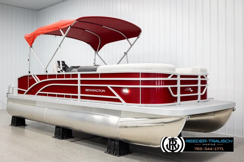 Slide: The Image of 2026 Bennington SSBSF pontoon boat with red canopy in showroom. - 3