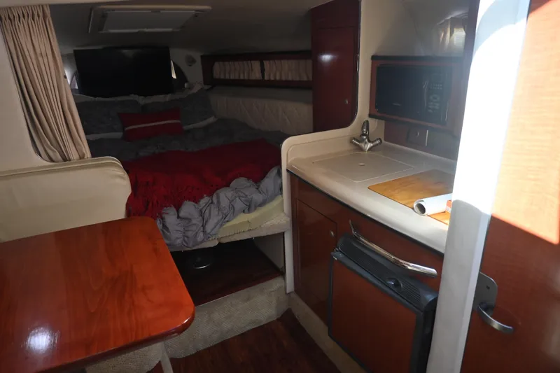 Slide: The Image of 2005 Sea Ray Sundancer 280 cabin interior with kitchenette and cozy sleeping area. - 17
