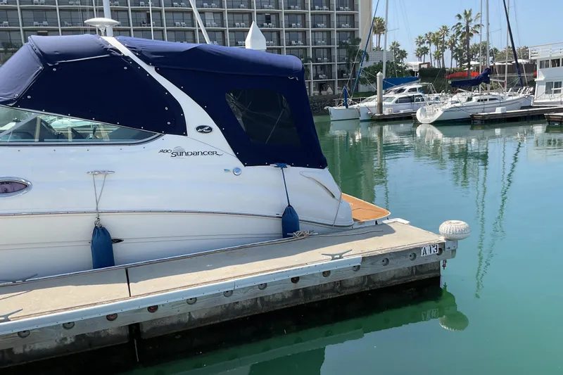 Slide: The Image of 2005 Sea Ray Sundancer 280 docked at marina with calm water and nearby boats. - 35