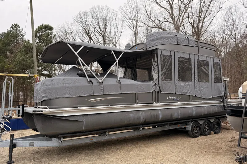 Slide: The Image of 2022 Premier 350 Escalante pontoon boat with full cover on trailer, parked outdoors. - 25