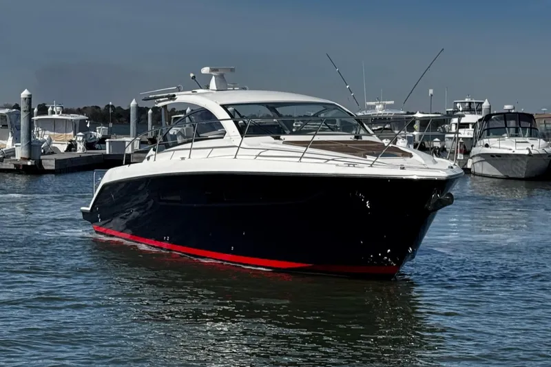 Slide: The Image of 2014 Pursuit SC 365i Sport Coupe yacht docked in marina, sleek design, blue hull. - 11