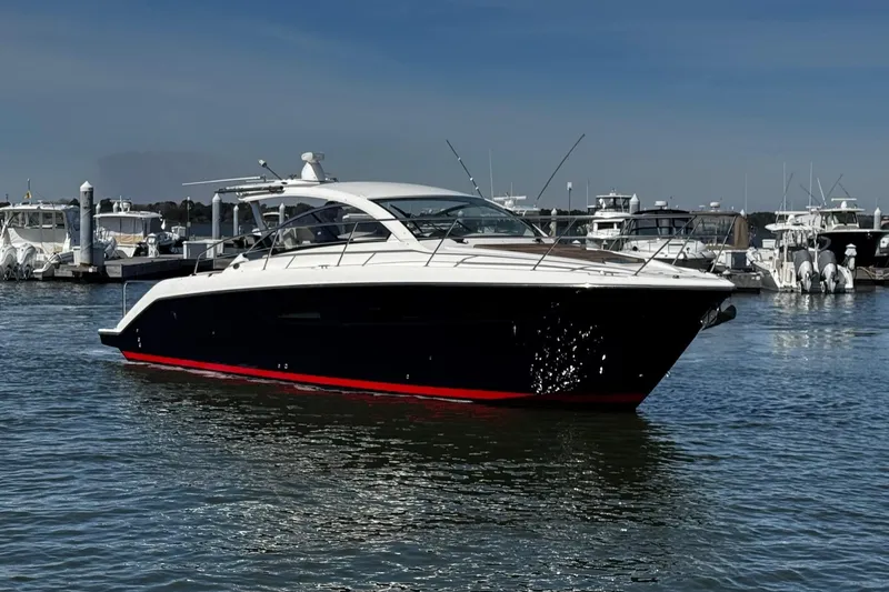 Slide: The Image of 2014 Pursuit SC 365i Sport Coupe yacht docked in a marina, sleek design, calm waters. - 12