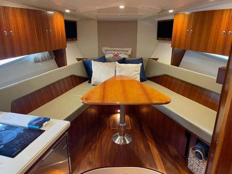 Slide: The Image of Luxurious interior of 2014 Pursuit SC 365i Sport Coupe with wood finishes and seating area. - 19