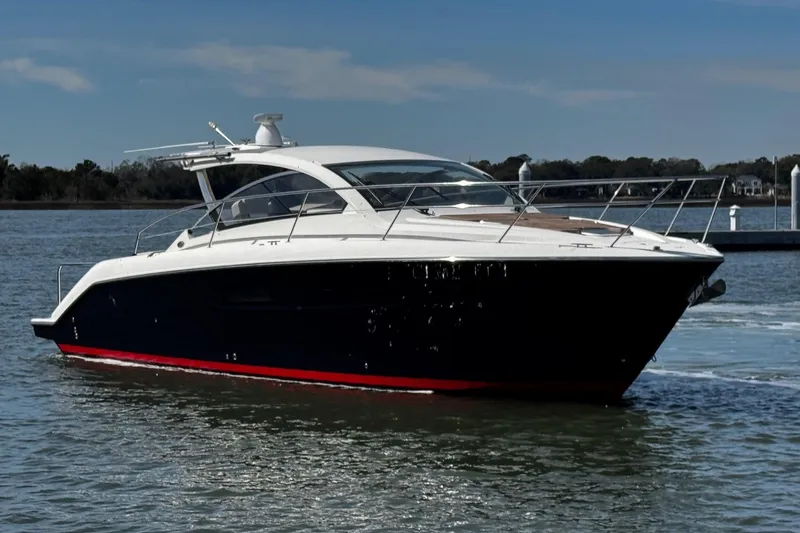 Slide: The Image of 2014 Pursuit SC 365i Sport Coupe yacht on calm water, sleek design, sunny day. - 2