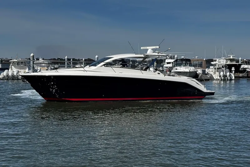 Slide: The Image of 2014 Pursuit SC 365i Sport Coupe cruising in a marina, surrounded by other boats. - 8